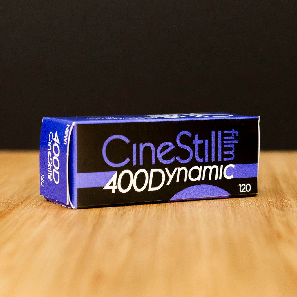CineStill 400 Dynamic film box on a wooden surface with a black background