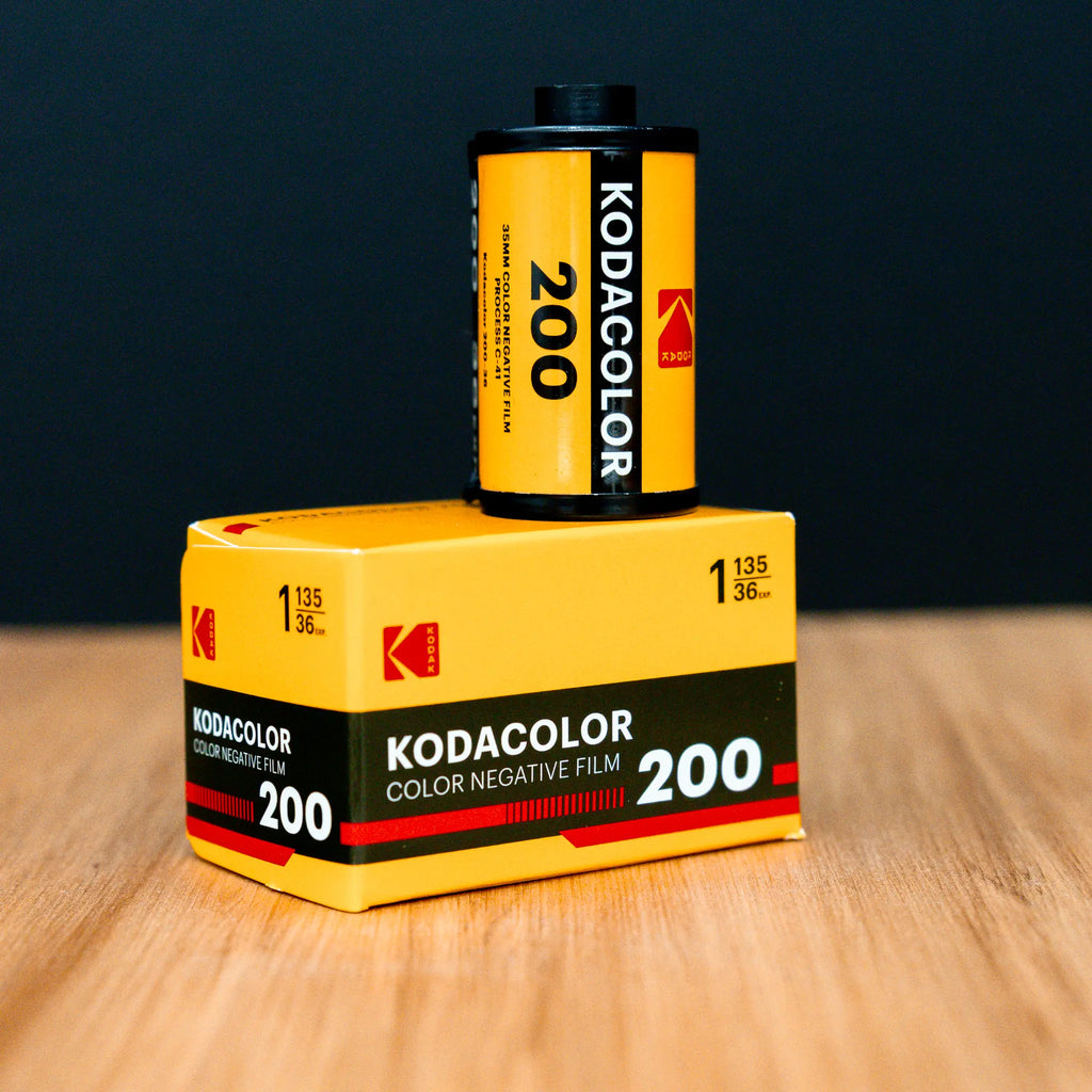 Kodacolor 200 film canister and box on a wooden surface with a dark background