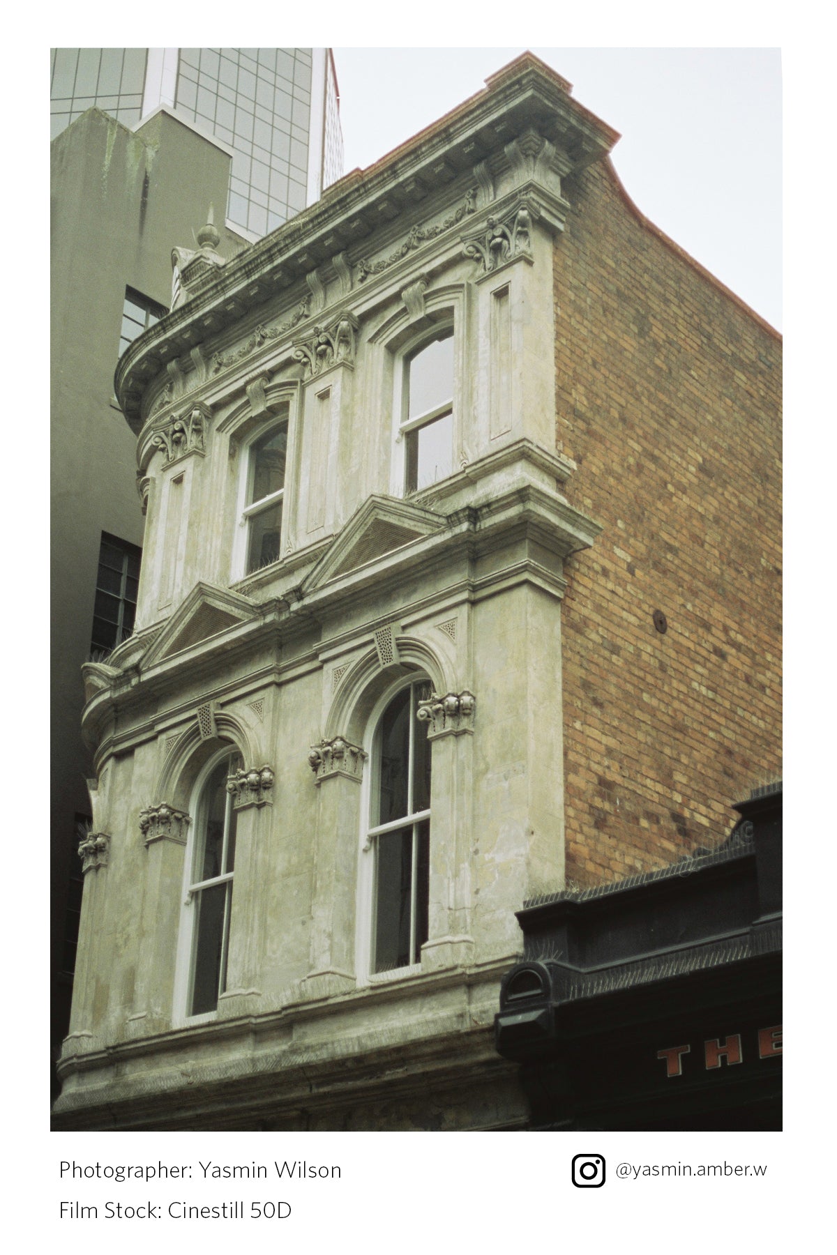 Corner of an old building with ornate architecture against a modern skyscraper shot on Cinestill 50D