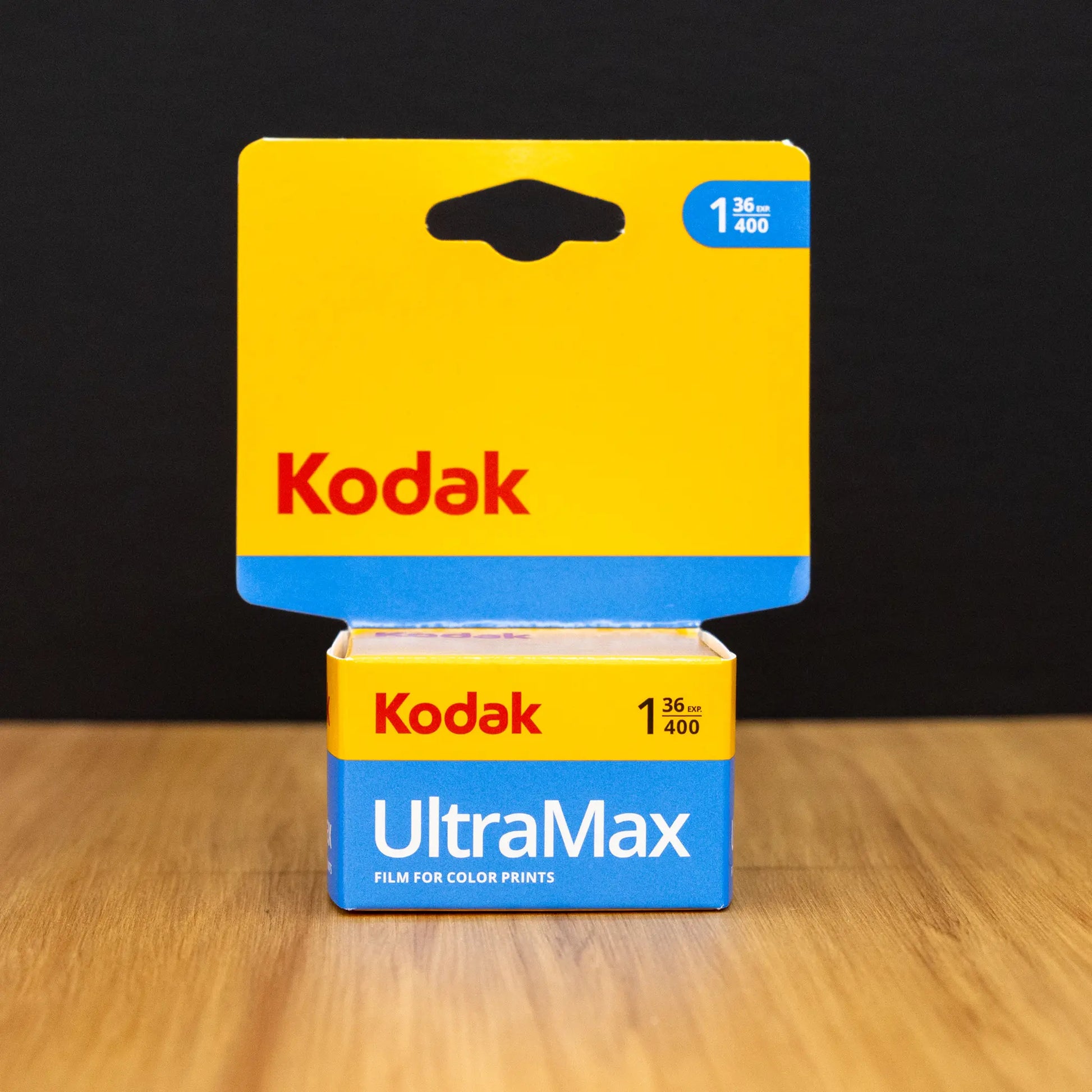Kodak UltraMax film packaging box on a wooden surface with a black background