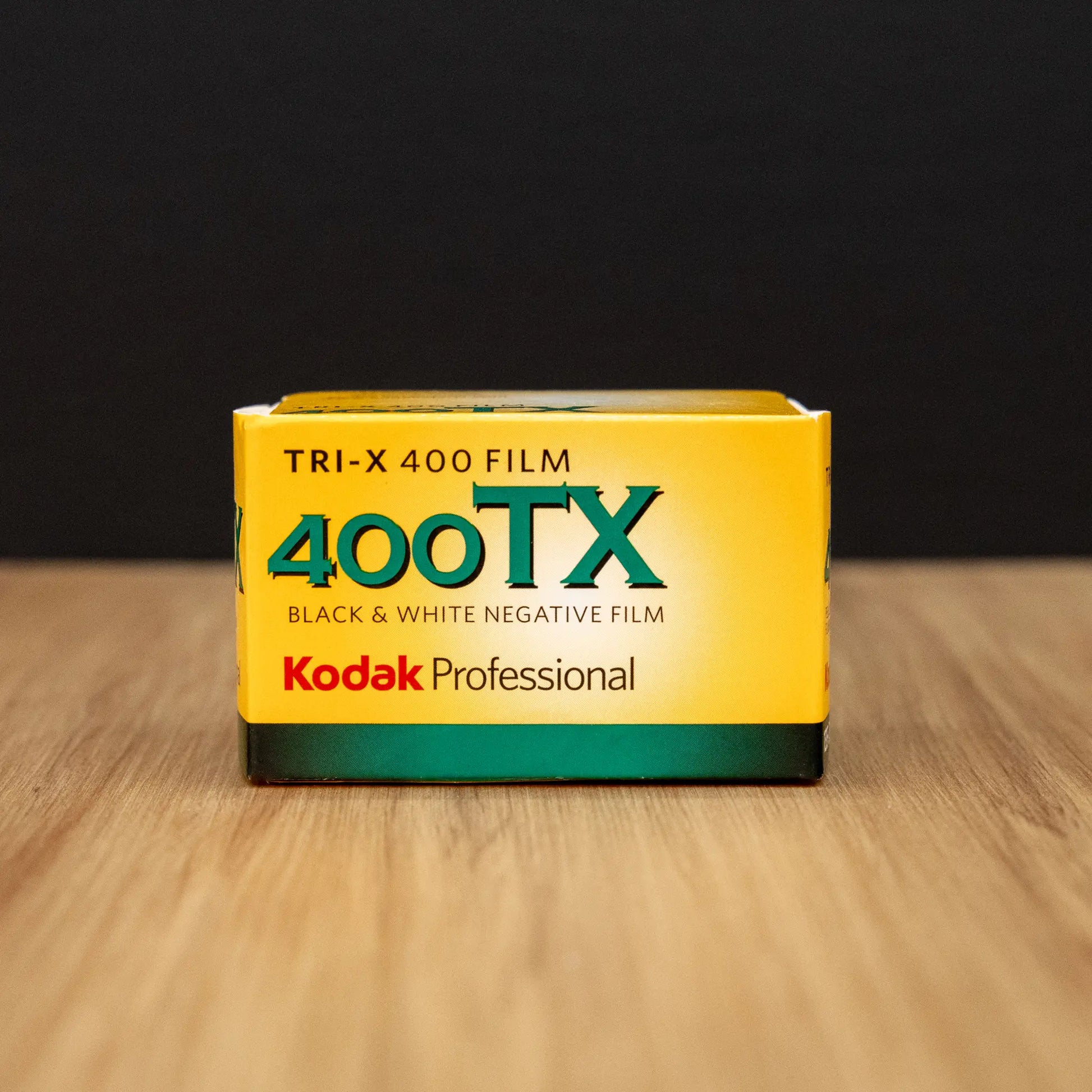 Kodak Professional 400TX black and white negative film box on a wooden surface with a dark background