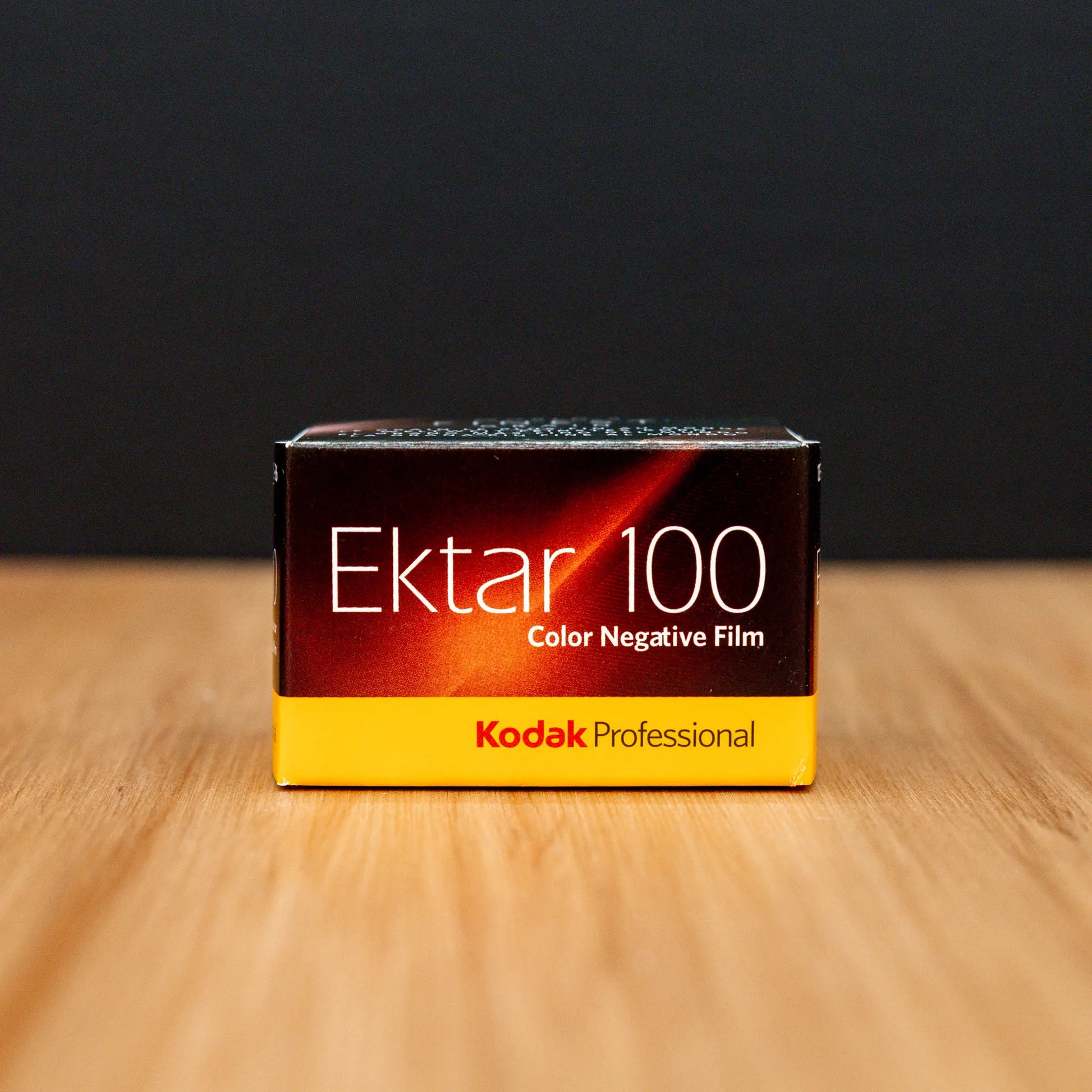 Kodak Ektar 100 Color Negative Film box on a wooden surface with a black background