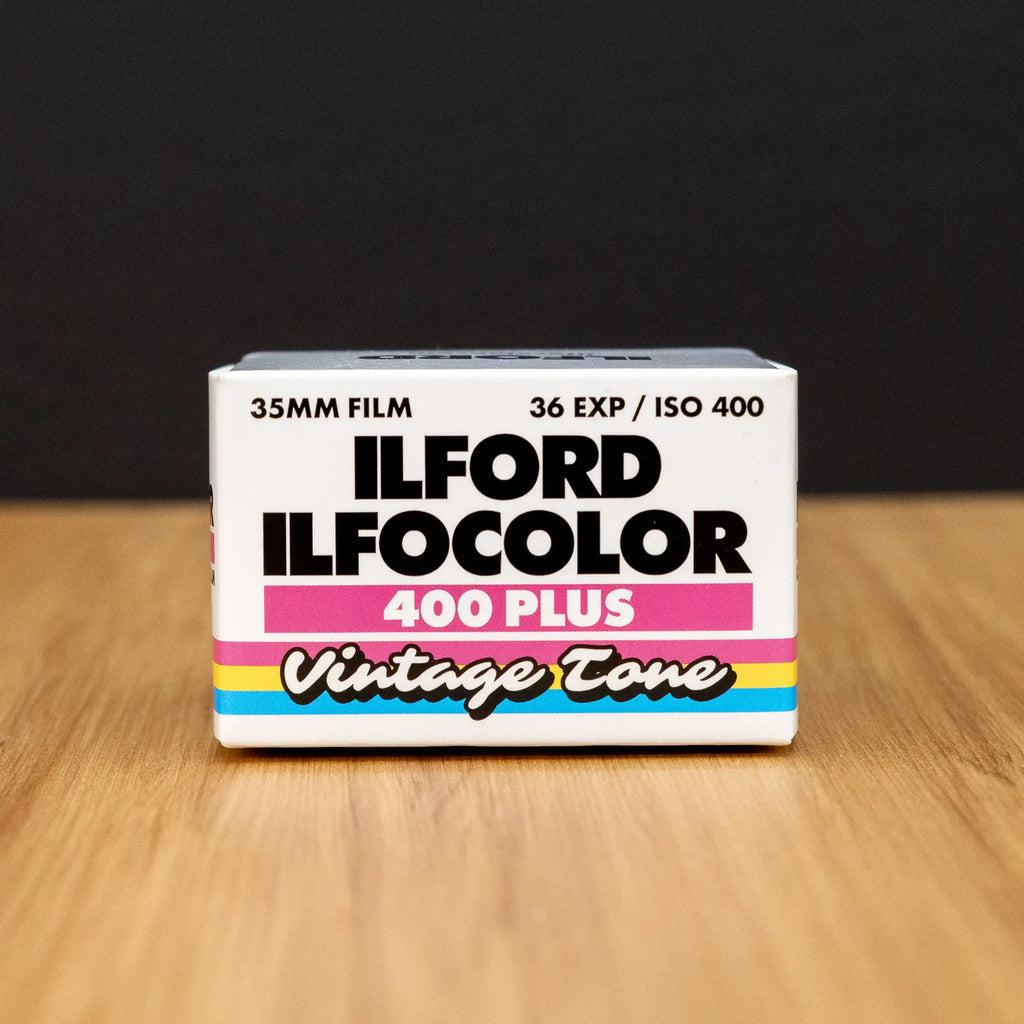Ilford Ilfocolor 400 Plus vintage tone film box on a wooden surface with a black background