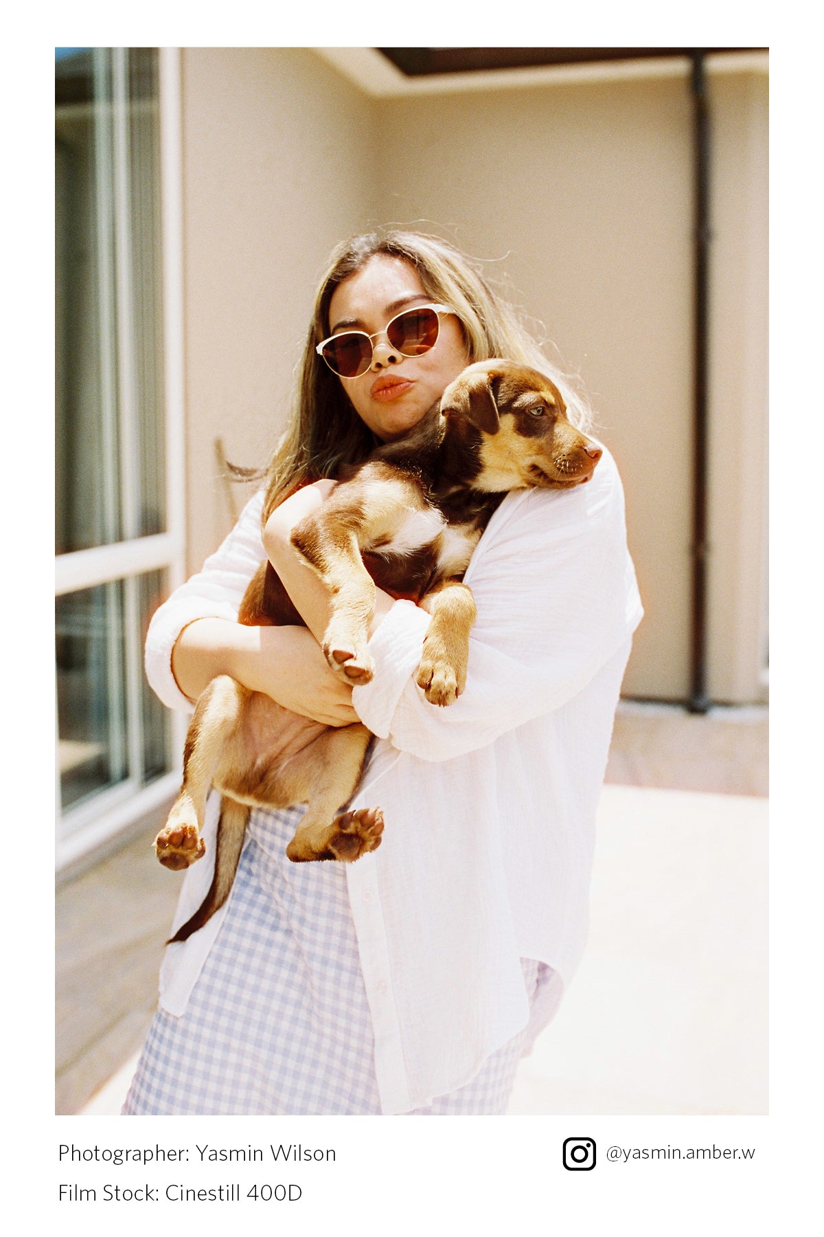 Woman holding a small dog on a balcony with a neutral background shot on Cinestill 400D