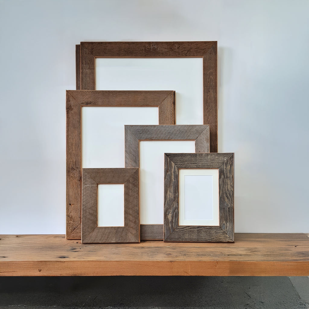 Set of Recycled oregon wooden picture frames on a wooden surface with a white background