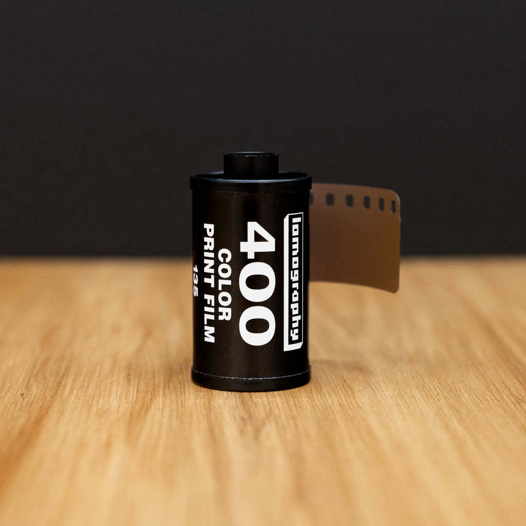 Film canister with 'Lomography' branding on a wooden surface