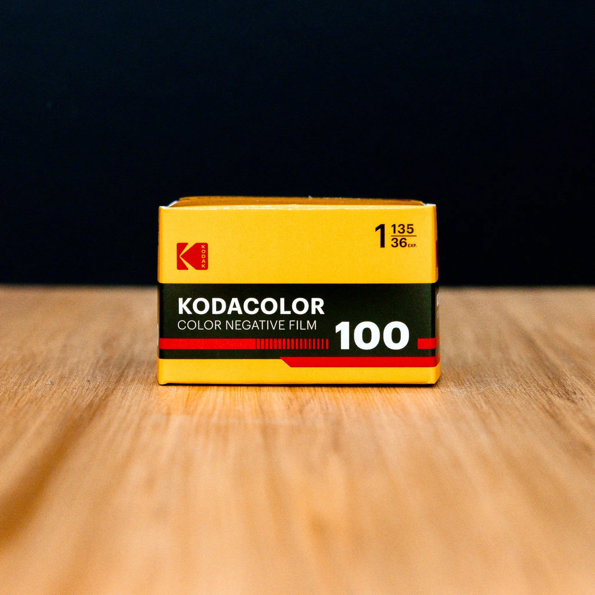Kodak KODACOLOR Color Negative Film 100 box on a wooden surface with a black background