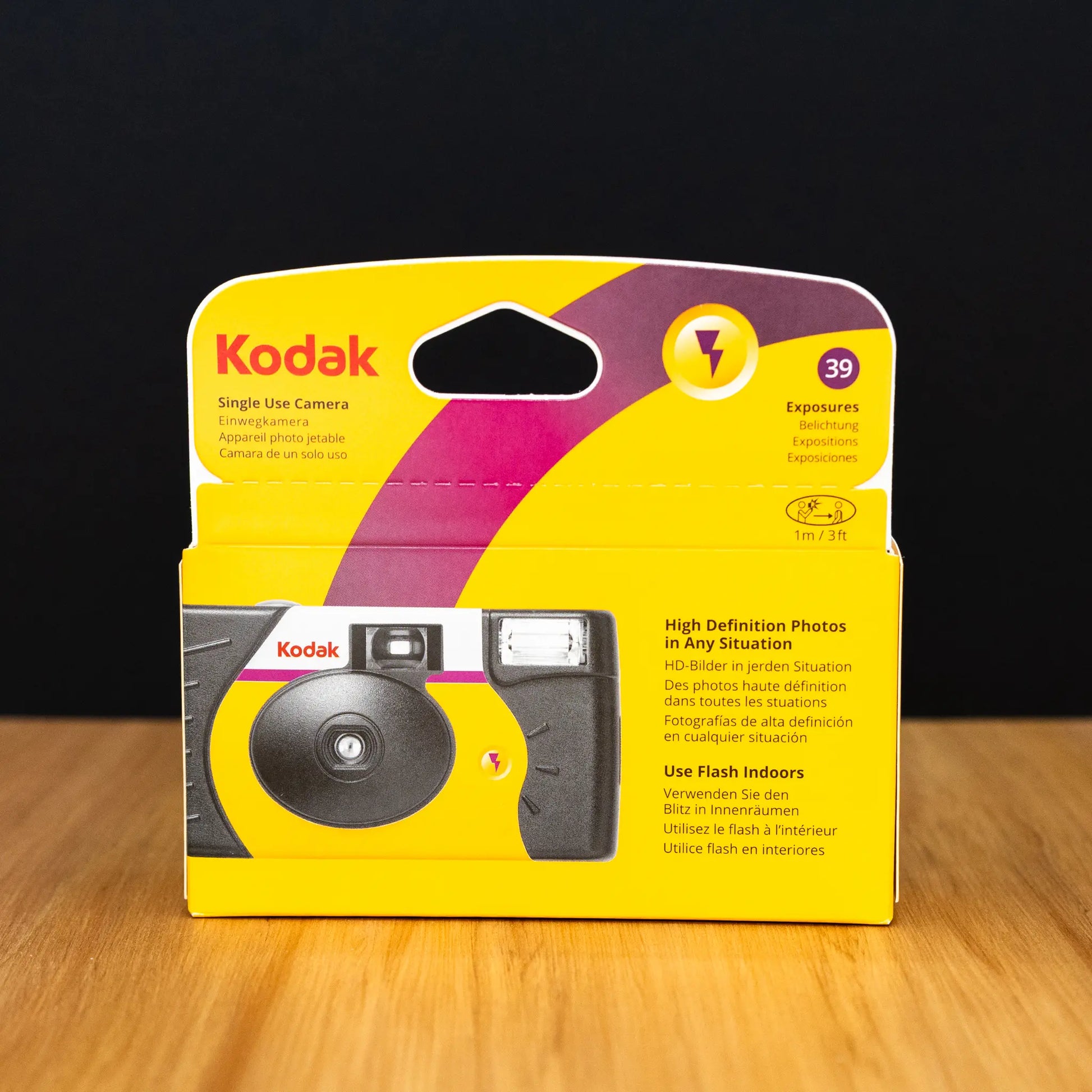 Kodak single-use camera packaging on a wooden surface with a dark background