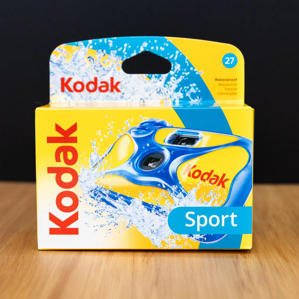Kodak Sport camera packaging on a wooden surface with a black background