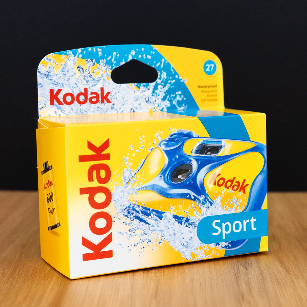 Kodak Sport camera packaging on a wooden surface with a black background